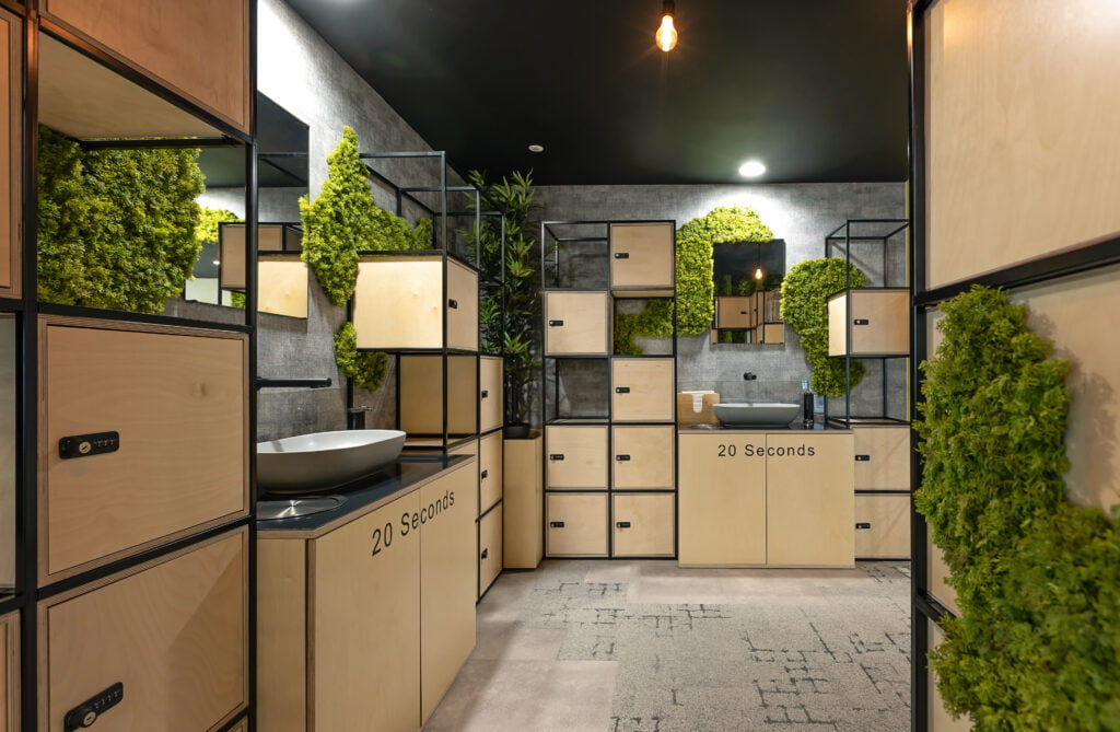 modern grey sinks surrounded by lockers and green foliage