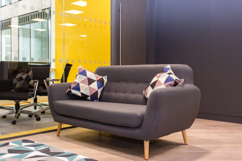 purple sofa with triangle pattern pillows in office lounge