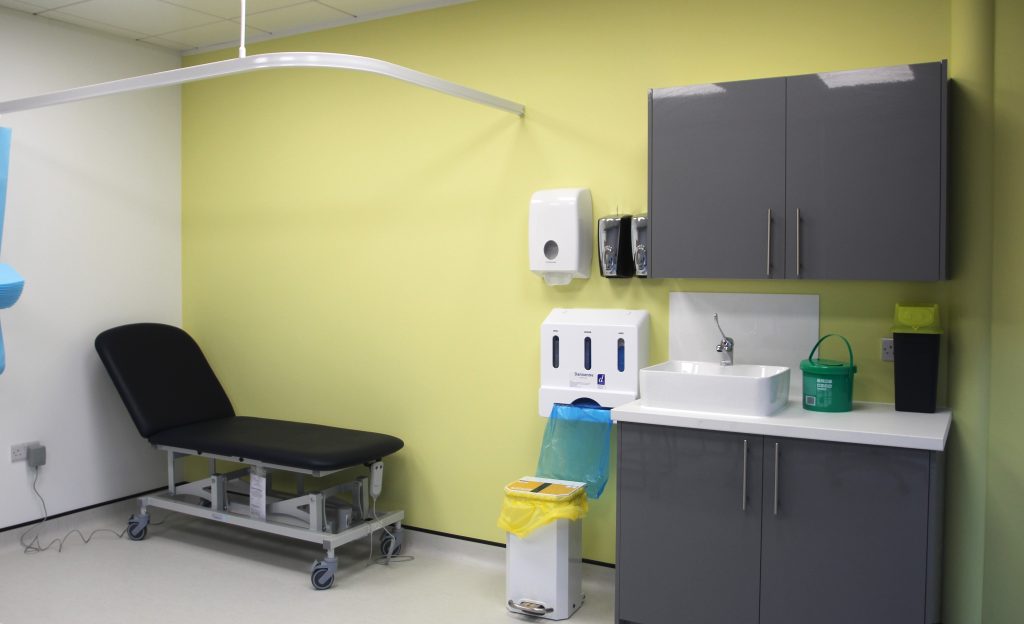 medical examination bed next to sink and grey cabinets