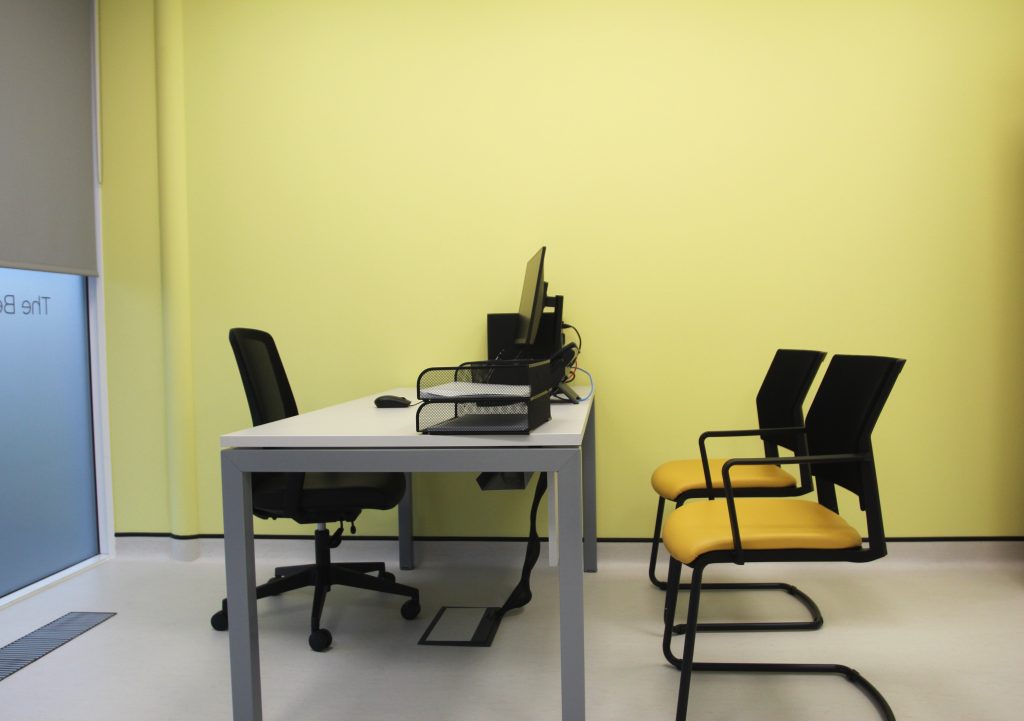 office desk with lime wall and yellow chairs