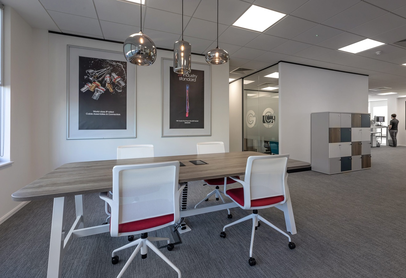 GCT office space with white and red wheeled chairs and branded posters