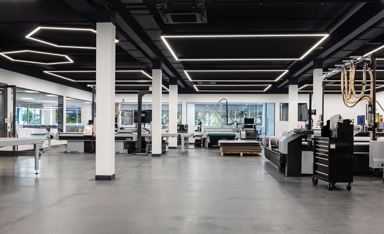 white and black modernised work space with machinery around the room with white support columns