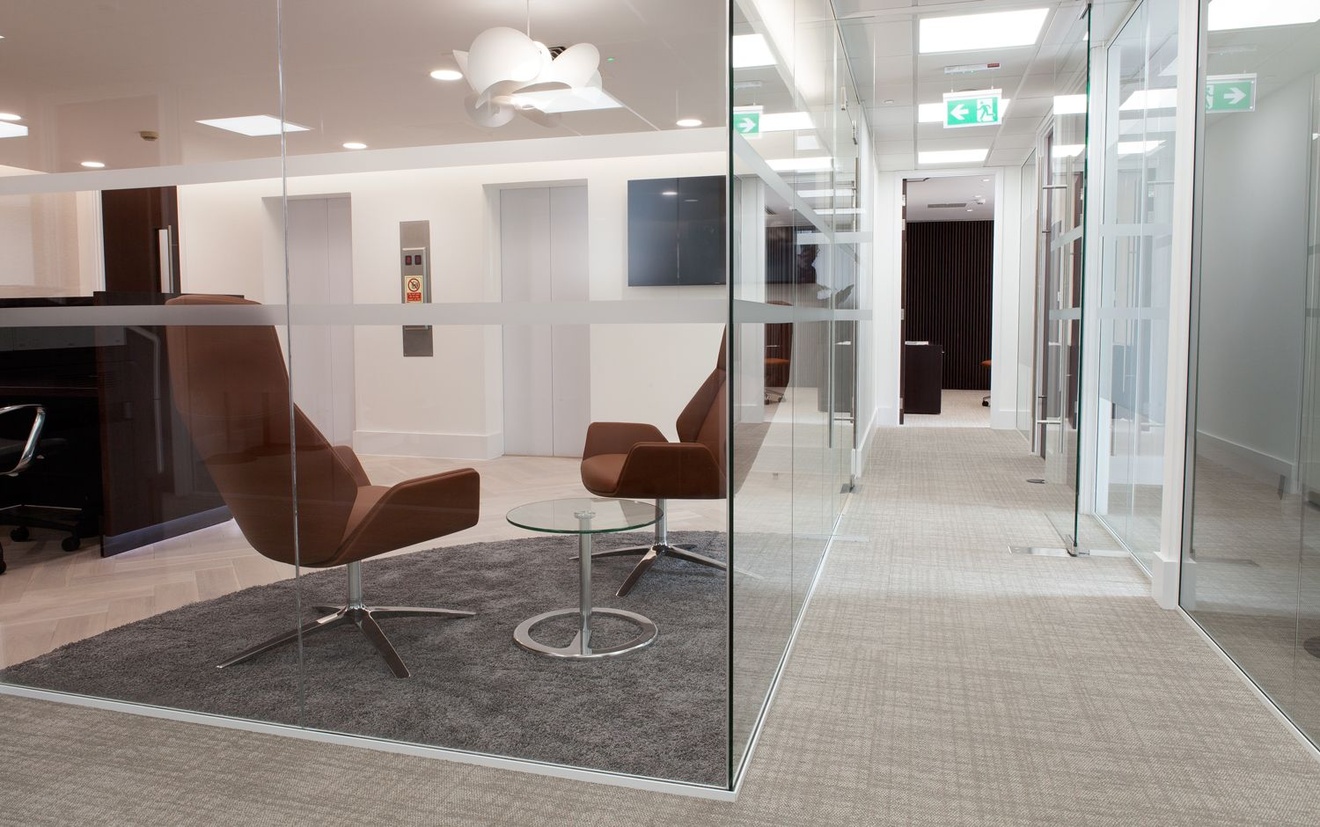 An office corridor with glass room either side.