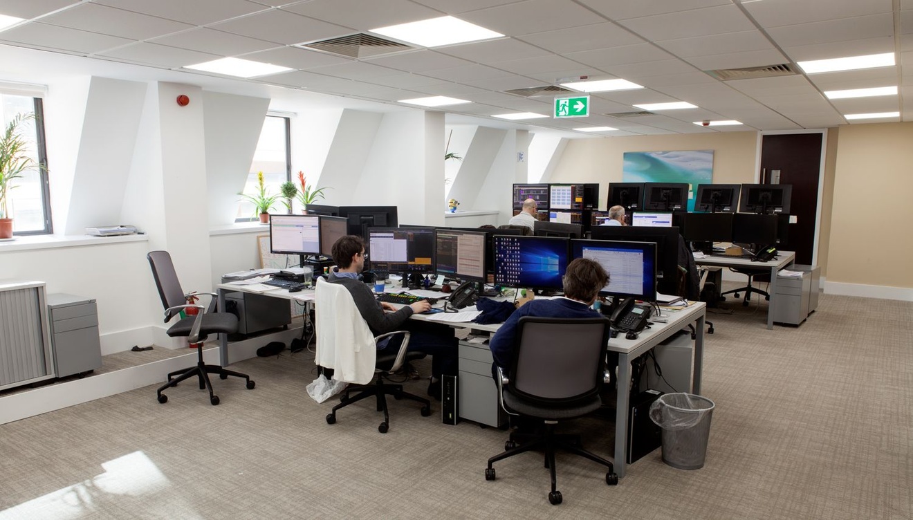 A busy office with employees sat working at their desks.