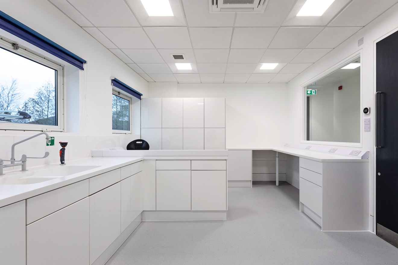 completely white minimalist kitchen area with two small windows