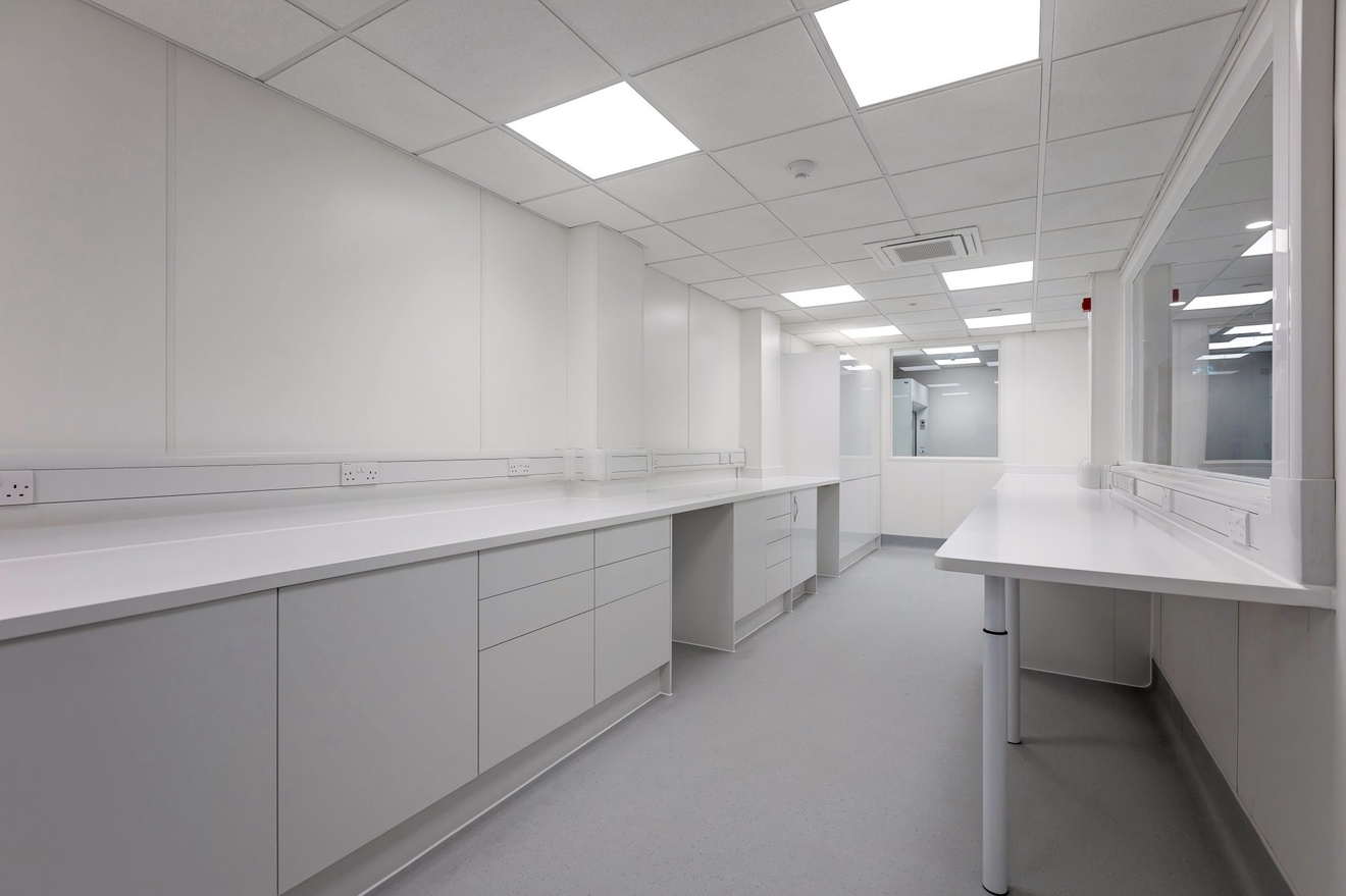 completely white dining area with minimalist cupboards and drawers with white box lights in the ceiling