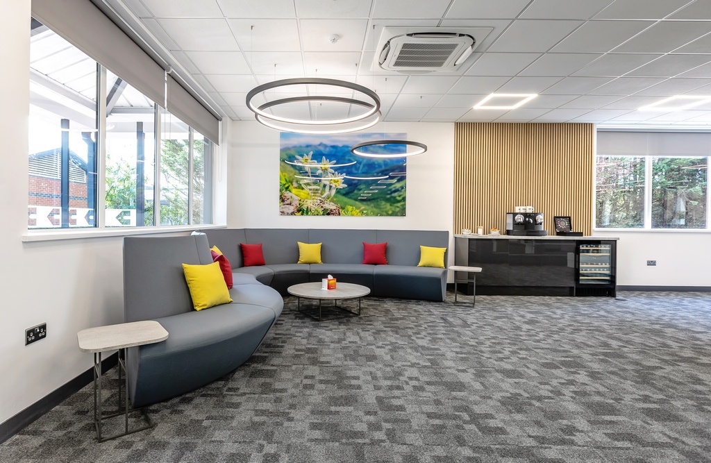 grey sofa sitting area in an S curve shape with coffee machine to the right