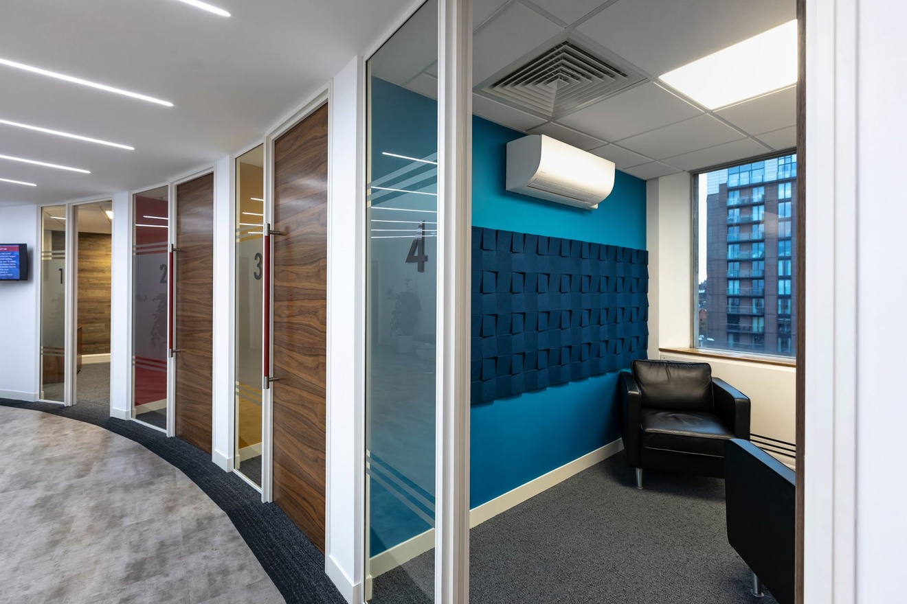 Four individual meeting rooms along a curved wall.