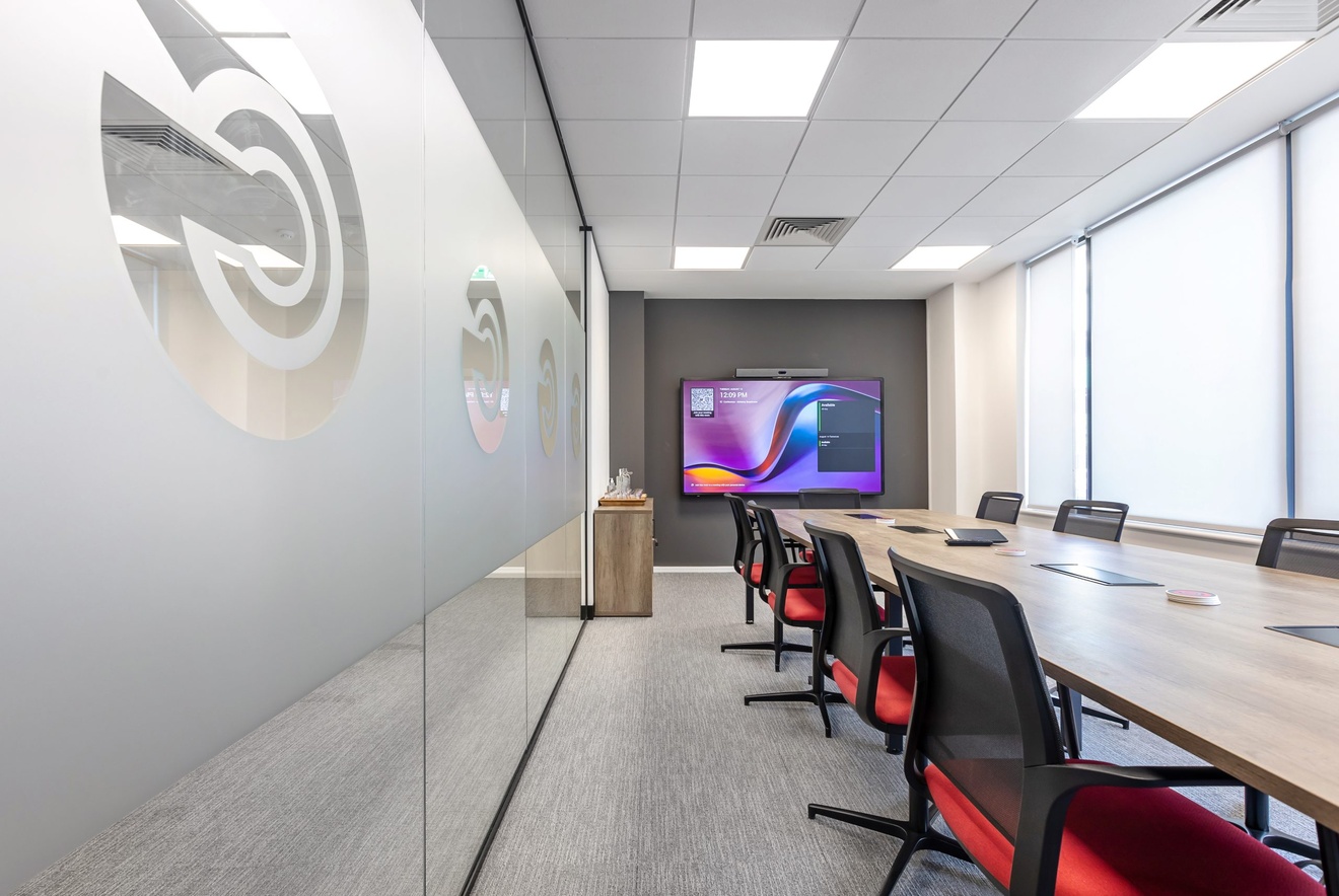 large GCT office board room interior with large tv and red chairs