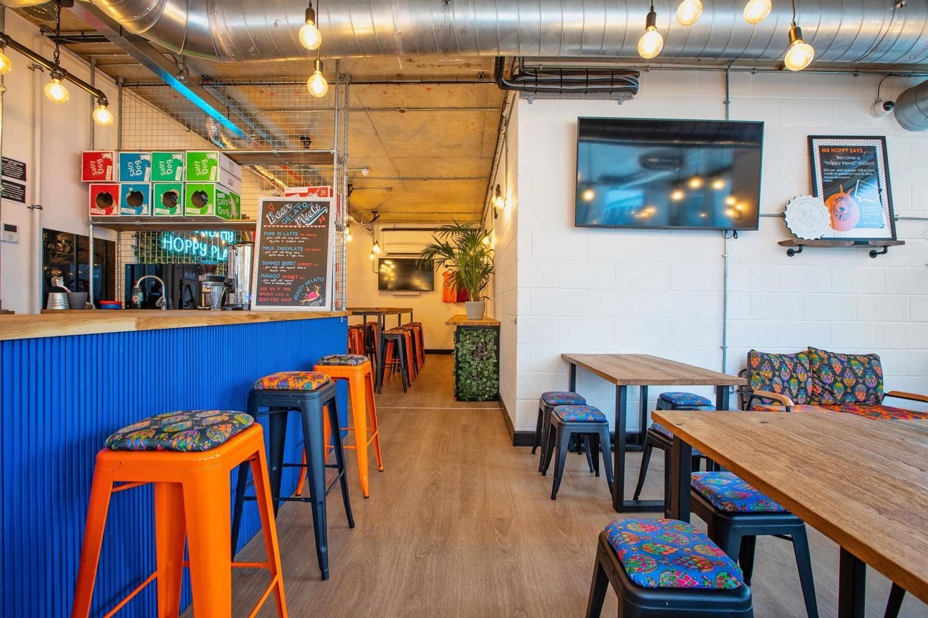 An empty restaurant with a blue bar and multiple seating areas.