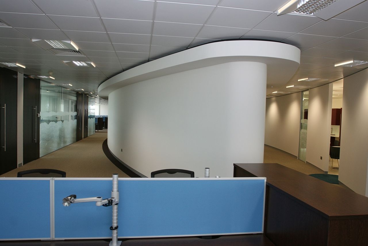 A hallway with a giant pillar in the middle of it.