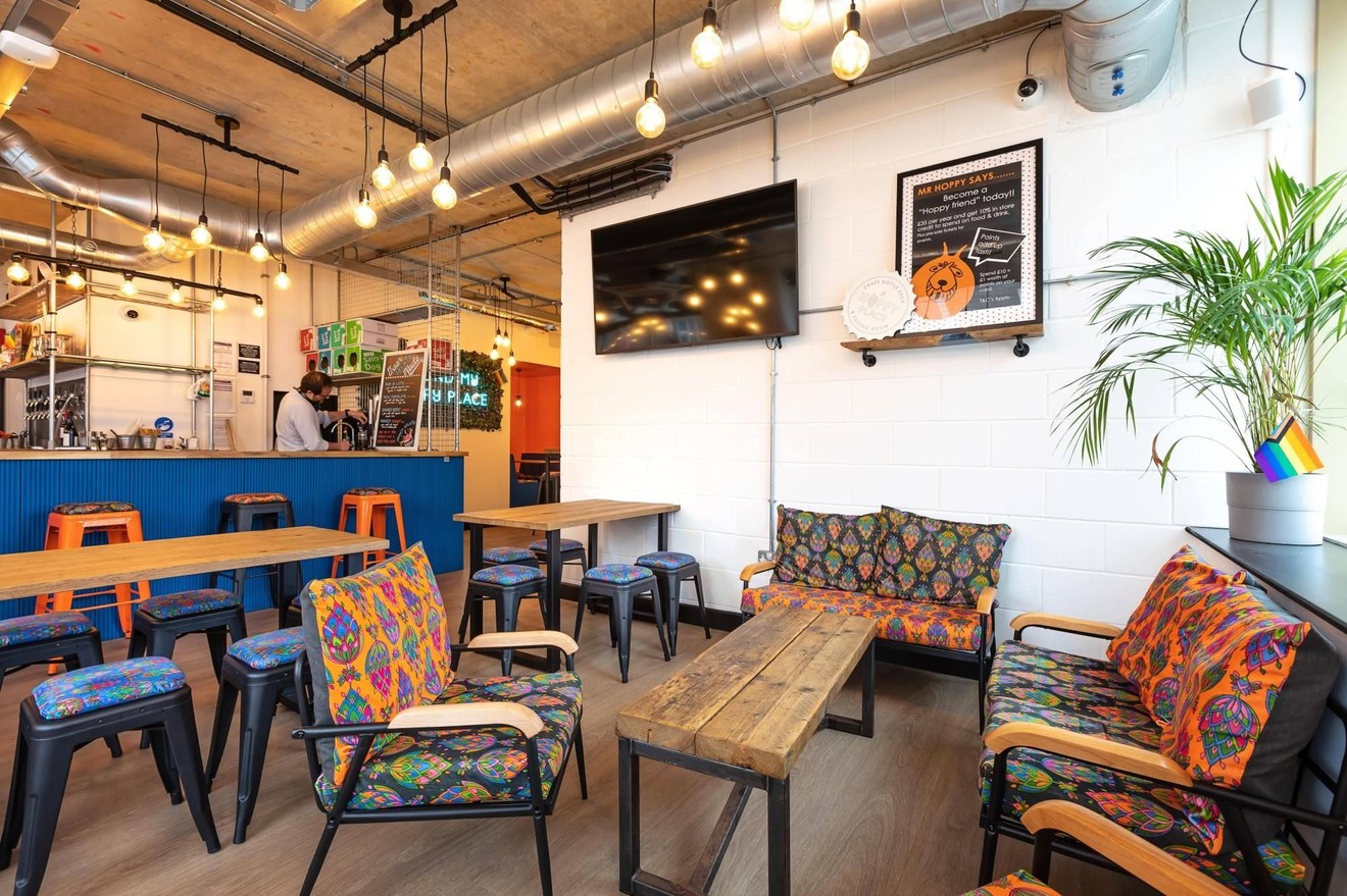 A seating area in an empty bar with a bench-style coffee table in the middle.