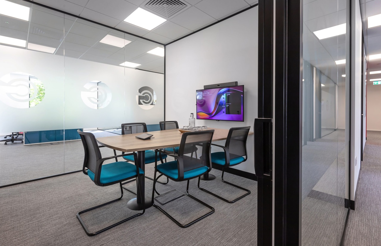 small office board room with flat screen tv and five blue chairs