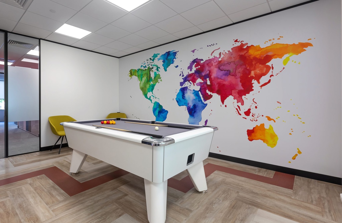 pool table in front of colourful world map on the wall