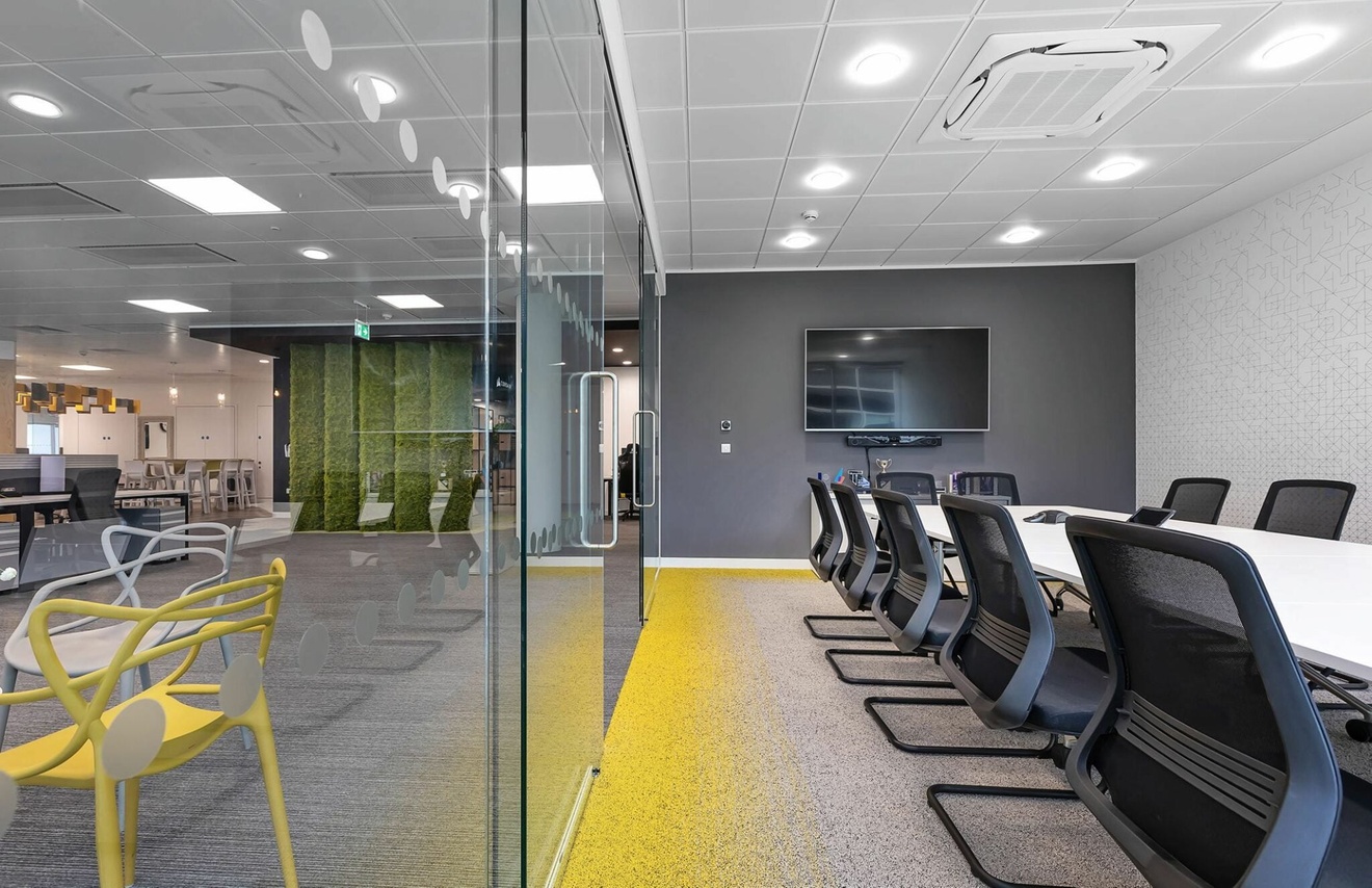 Looking down a meeting room with a glass wall on the left side.