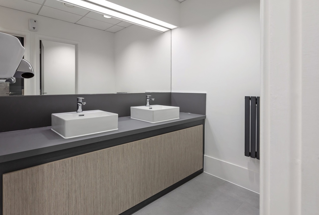 minimalistic black and white bathroom with square sinks and large back mirror an hand dryer