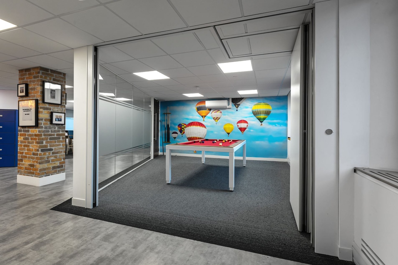 a breakout area with bifold doors and a pool table inside.