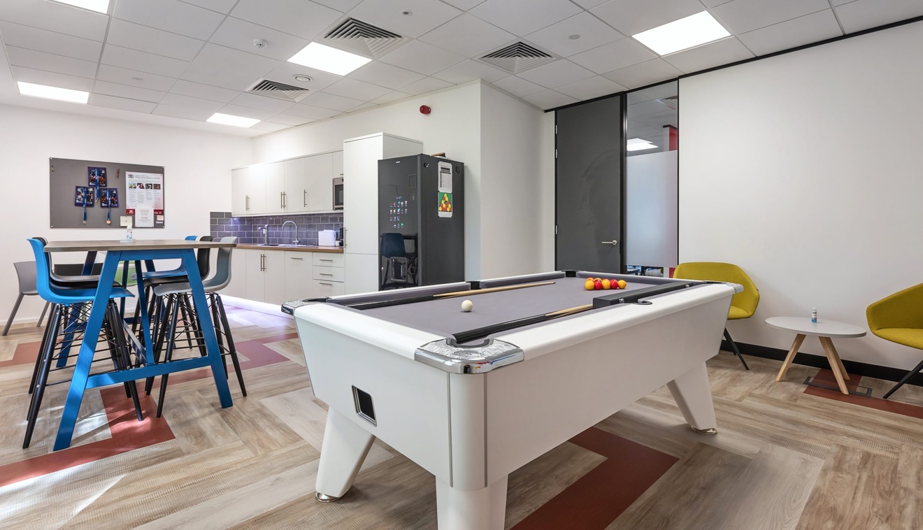 office kitchen with white pool table in the centre