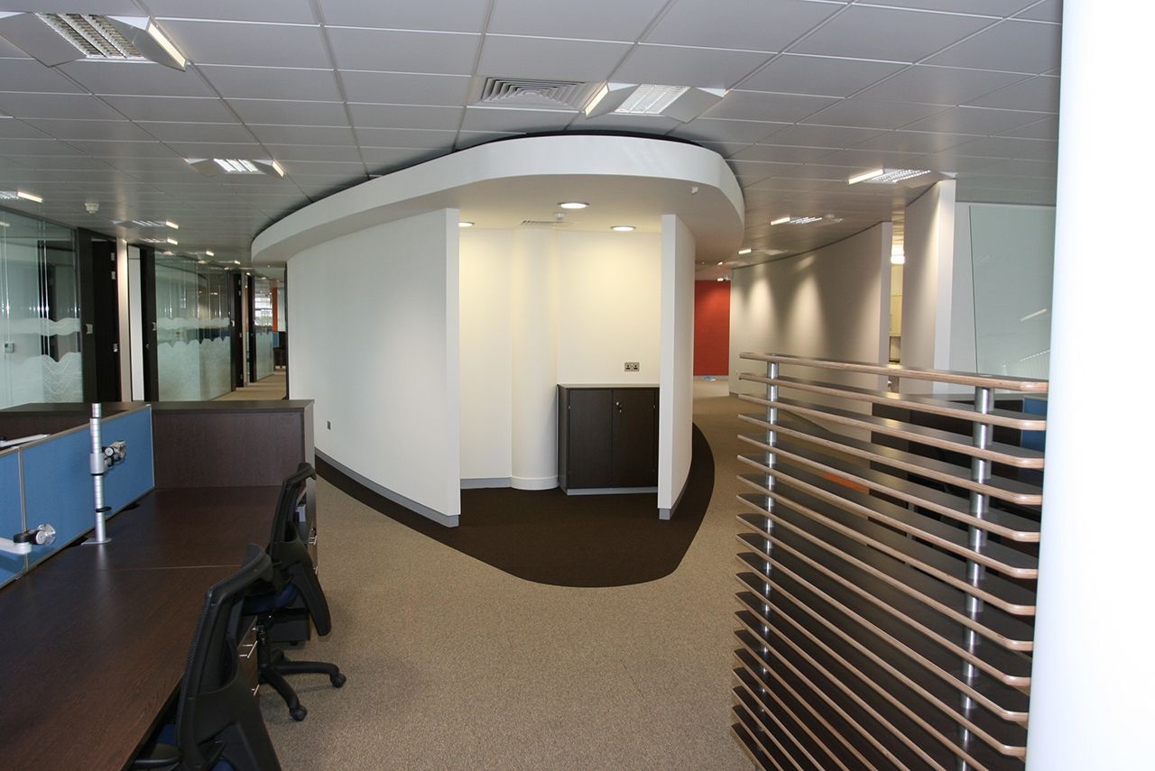 A hallway with a big pillar in the middle of it.