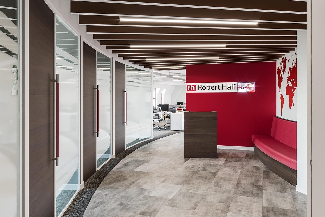 A reception area with seating area and meeting rooms opposite.
