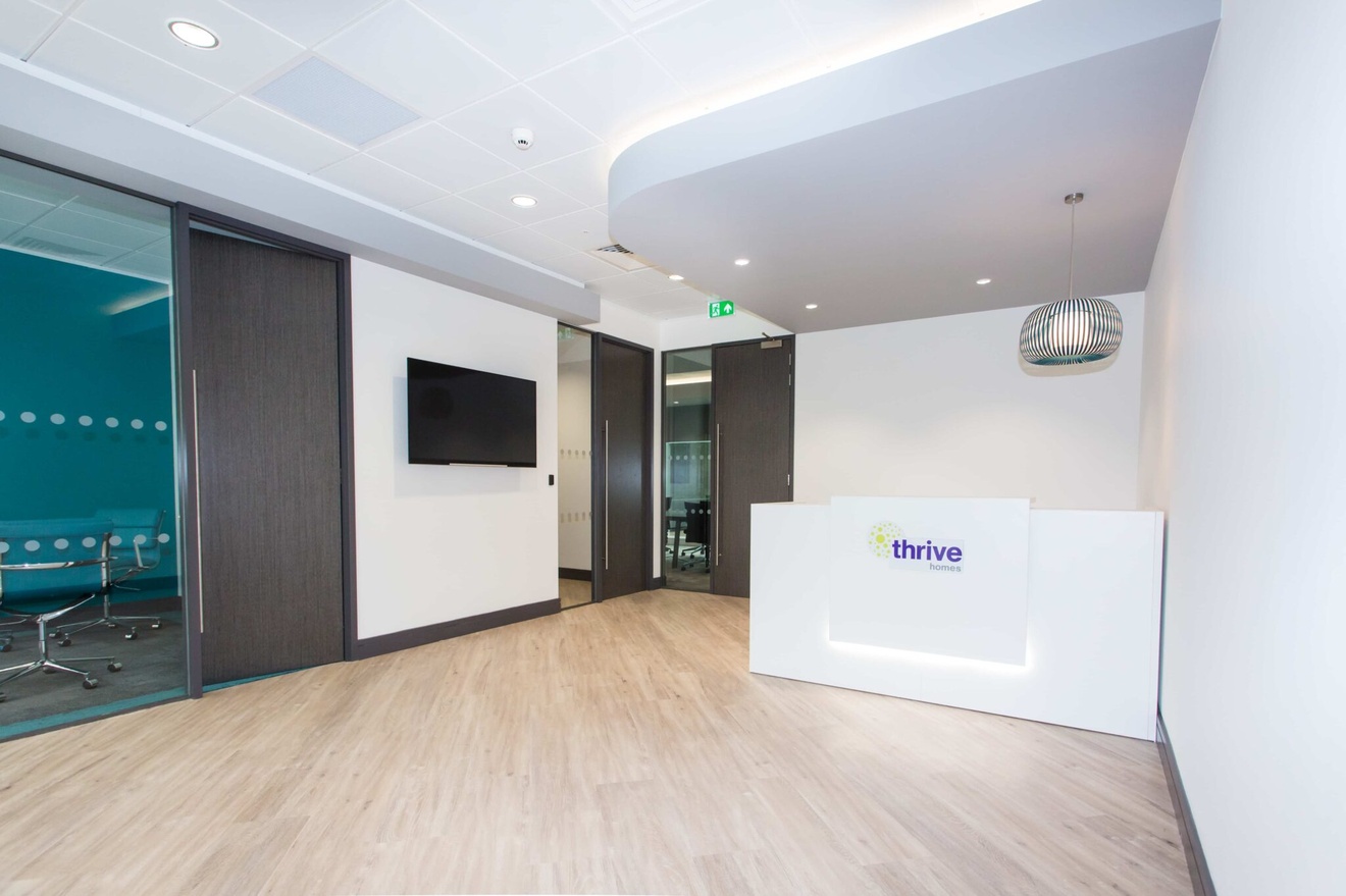 A reception with a front desk and meeting rooms.