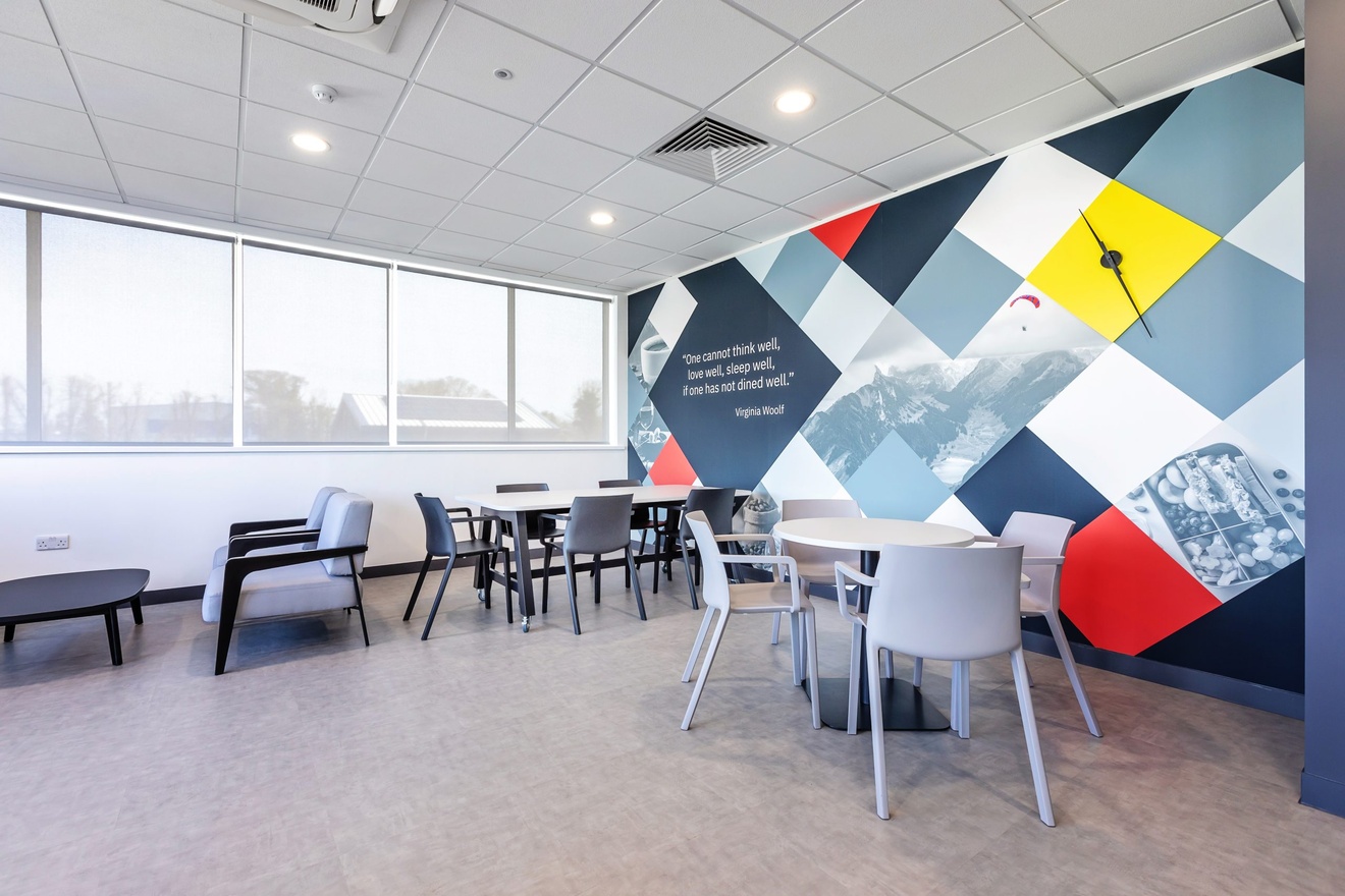 dining area with four tables large windows and a checkerboard wall with a virginia woolf quote written on it