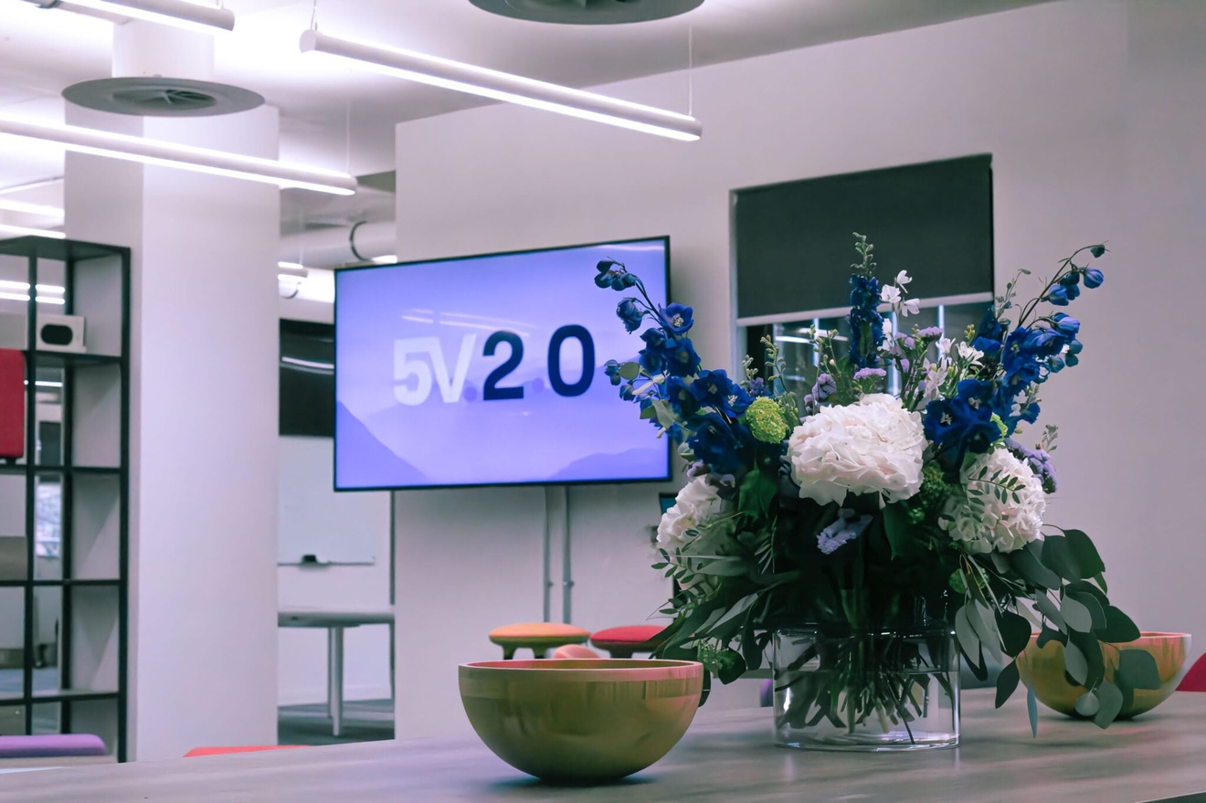 A closeup of table decorations, including a vase with glowers and two bowls.