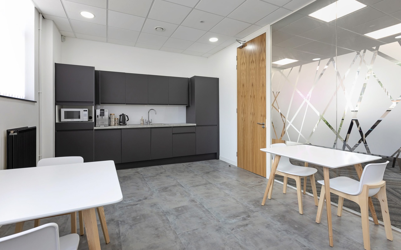 modern black and white kitchen with small white tables and chairs to the left and right