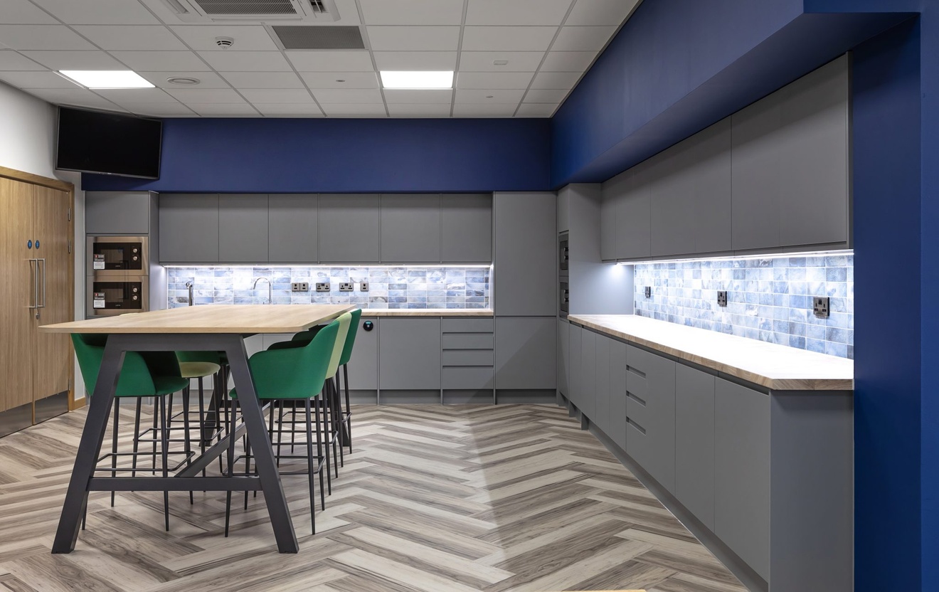 teapoint area with herringbone flooring and green high chairs