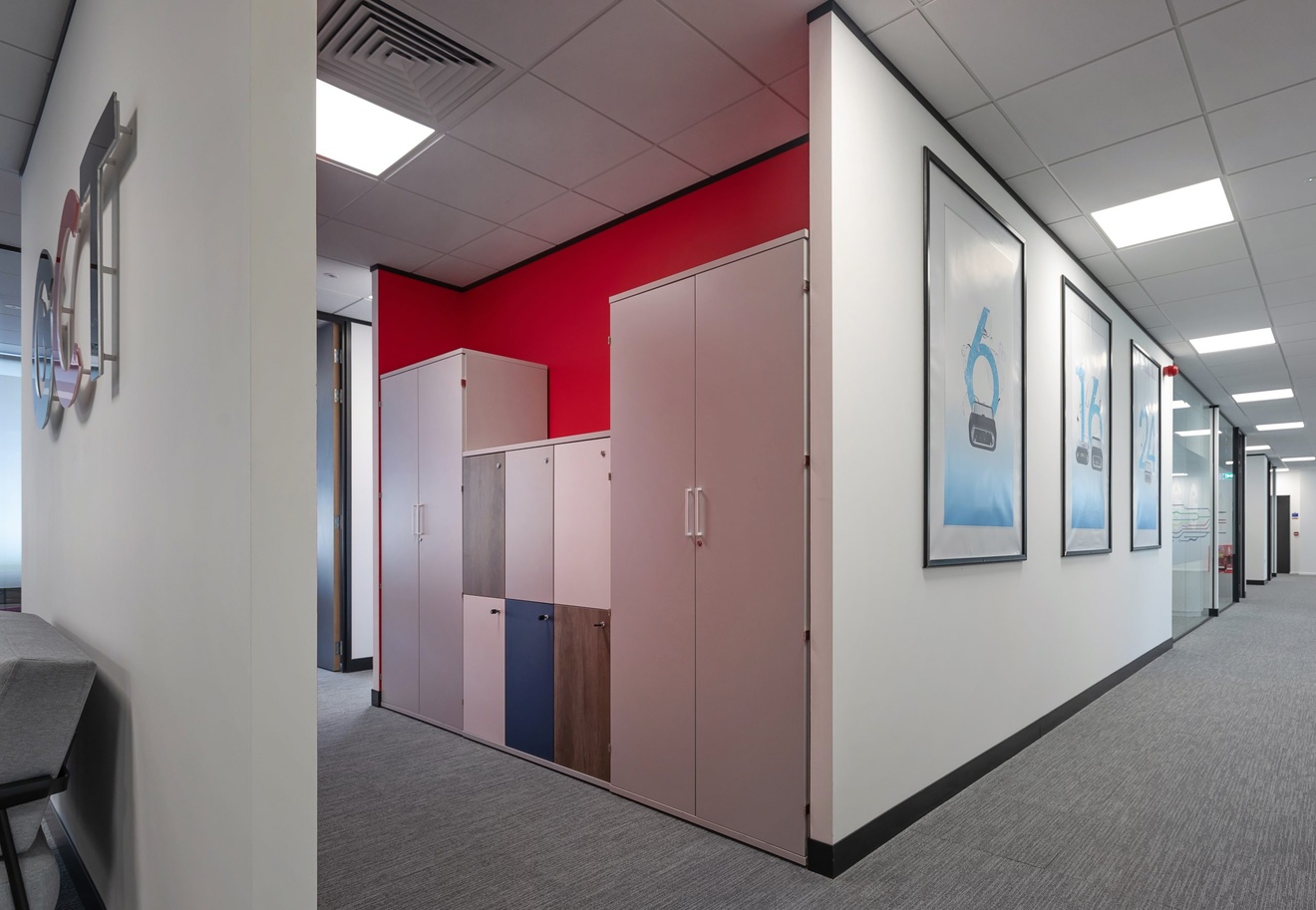 modern office corridor with red wall and posters and cabinets