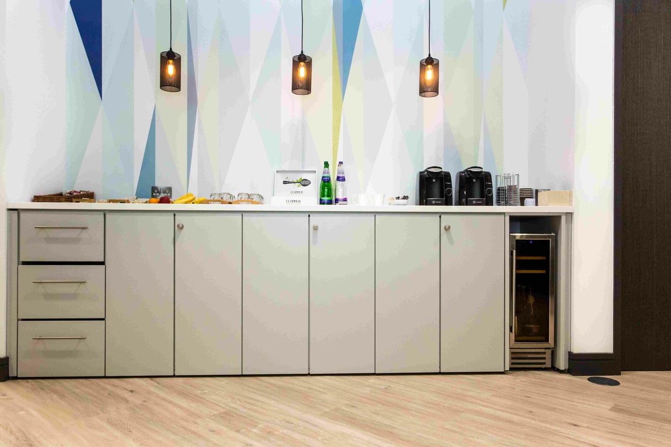 An office kitchen worktop with appliances on top of it.