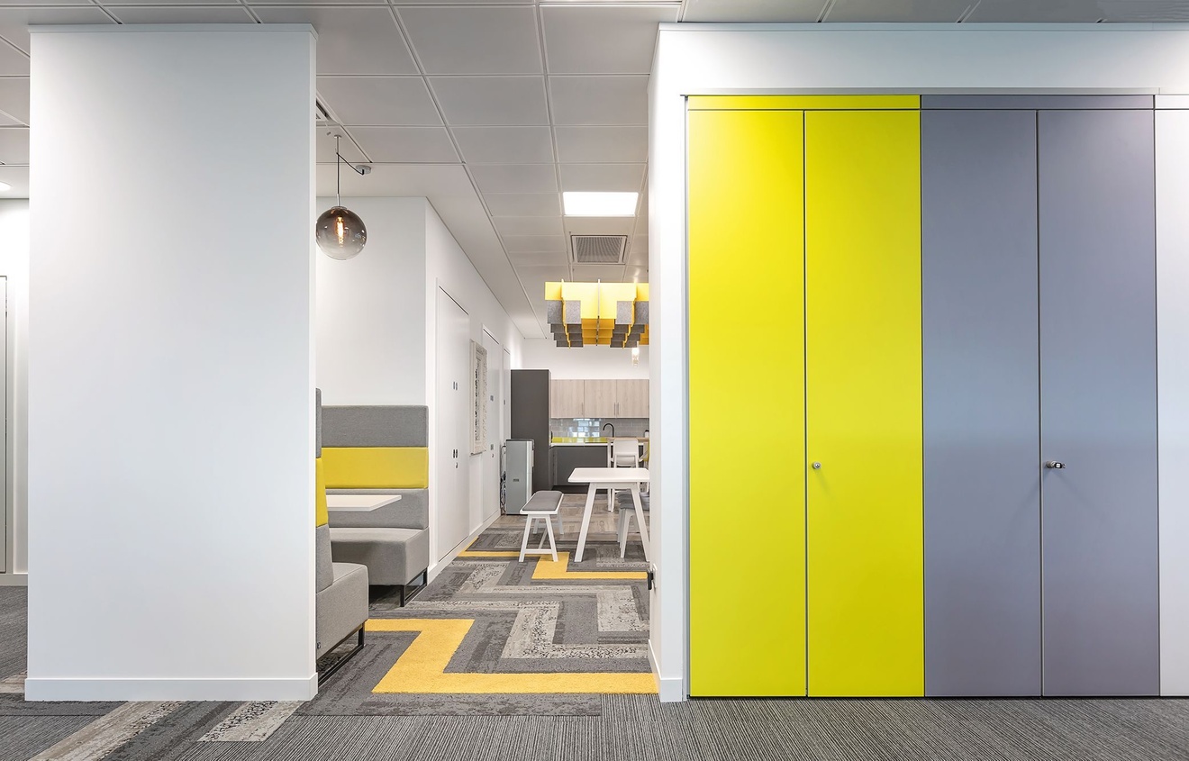 Bespoke office storage solutions with a private seating area next to it.