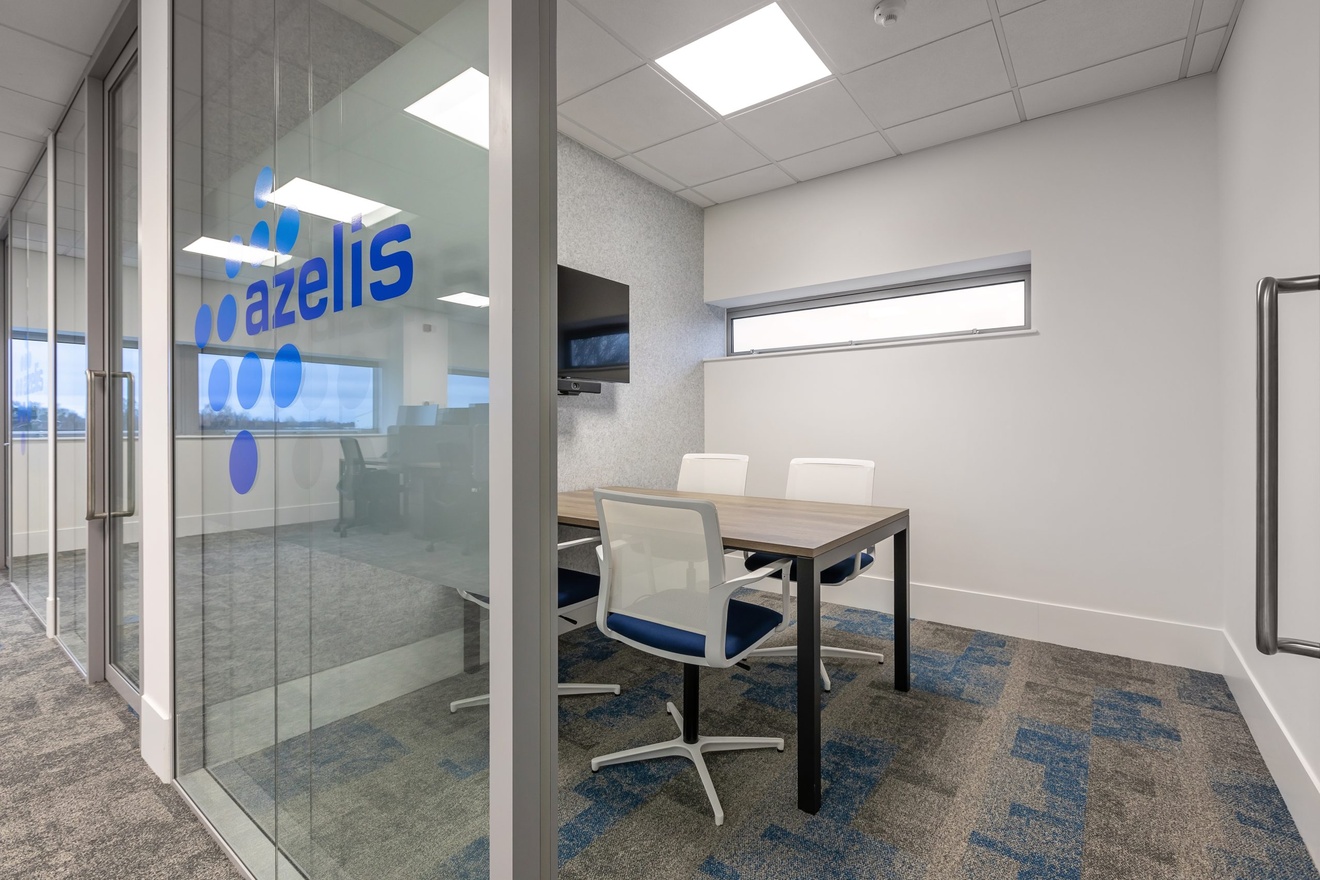 small meeting room with azelis logo on the glass door entrance with white and blue swivel chairs