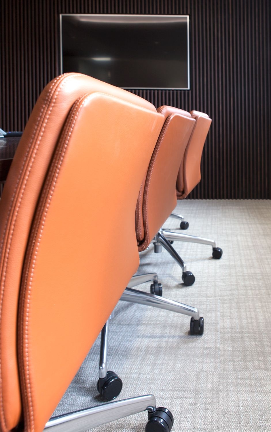 The back of three leather chairs in a row.