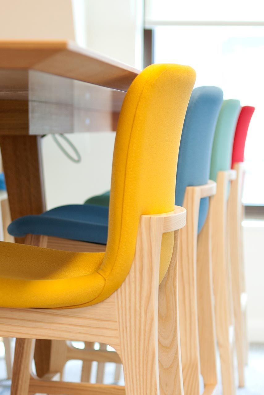 Closeup of multi-coloured chairs underneath a table.